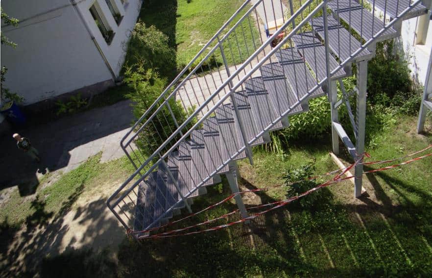Stahl Außentreppe Geradläufig verzinkt auf Stützen stehend als Außen Zugang zum 1 OG mit Podest & beidseitigem Treppengeländer als Wangen Konstruktion & Rundrohr Geländerstäben & Handlauf & Gitterroststufen