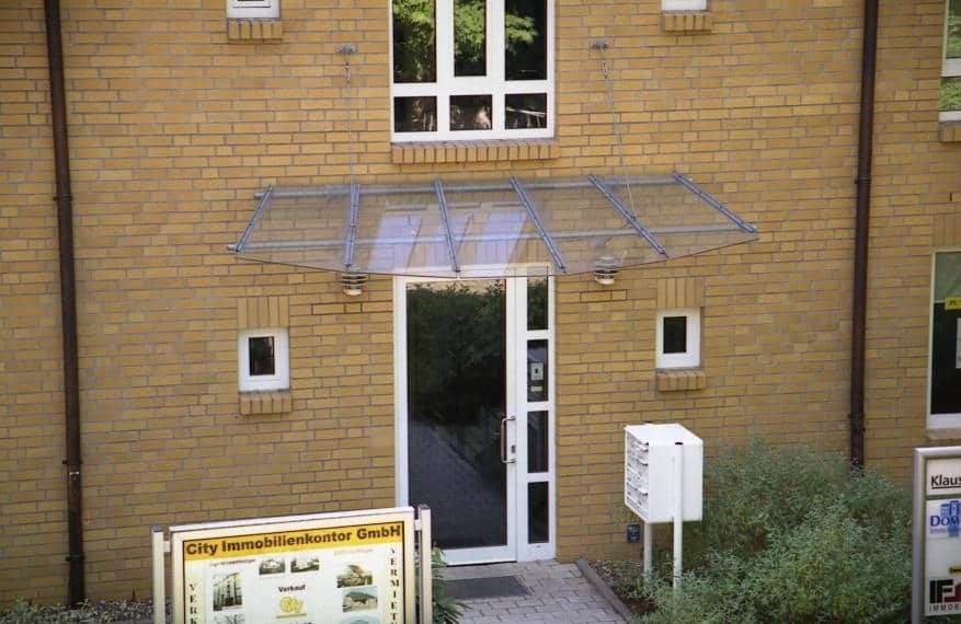 Stahl/Edelstahl Vordach abgehängt mit Zugstreben als Pultdach mit Bogenförmiger Scheibe TVG Verglasung 16 mm